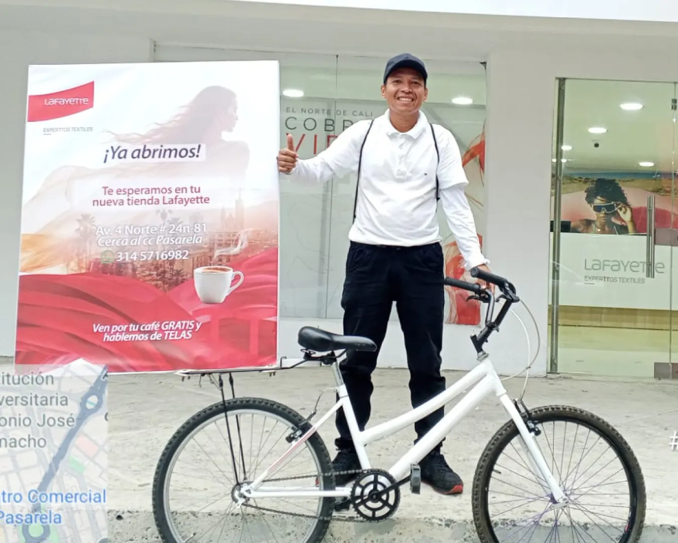 Promotor de Bagu Medios con bicicleta y valla de apertura de una tienda Lafayette