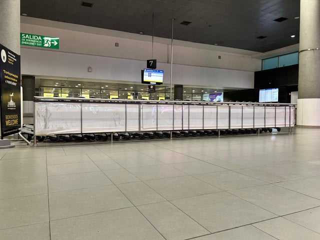 Miniatura: Asistente especializado ayudando con el manejo de equipaje en aeropuerto El Dorado