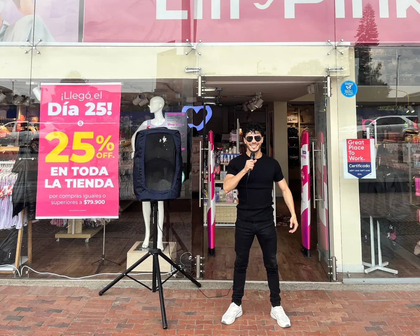 Locutor de Bagu Medios con micrófono y parlante haciendo perifoneo en la entrada de una tienda